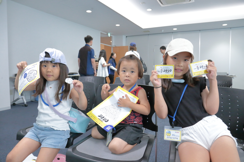 子どもたちが大阪府ジテシラProjectのグッズを手にする写真