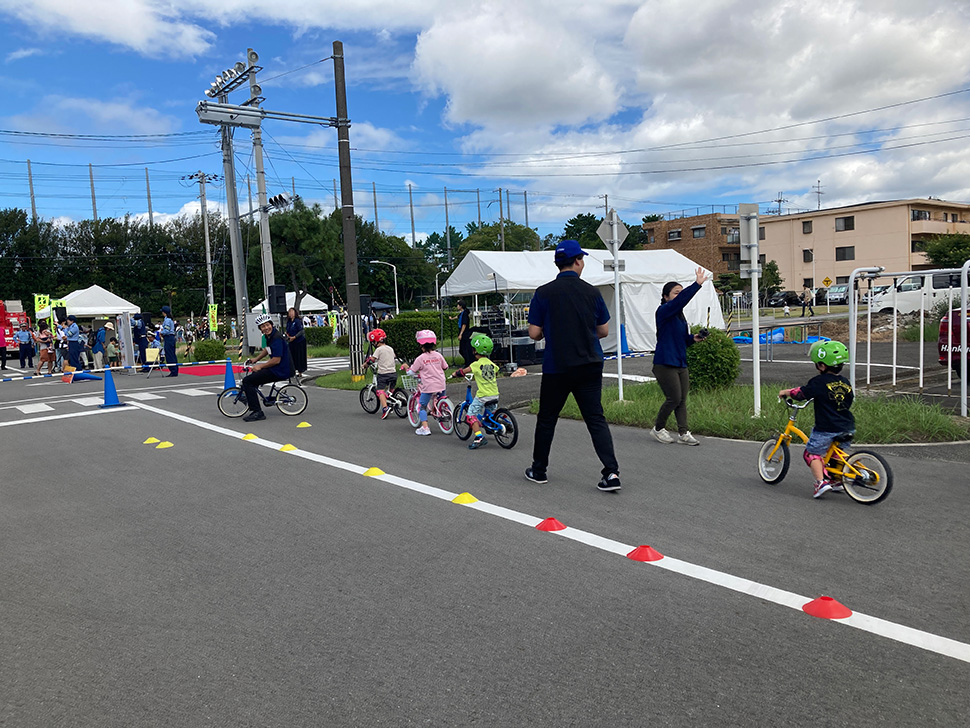 自転車のサドルにまたがって歩く練習をする子どもたち1