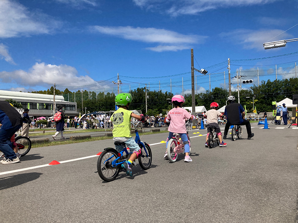 自転車のサドルにまたがって歩く練習をする子どもたち2