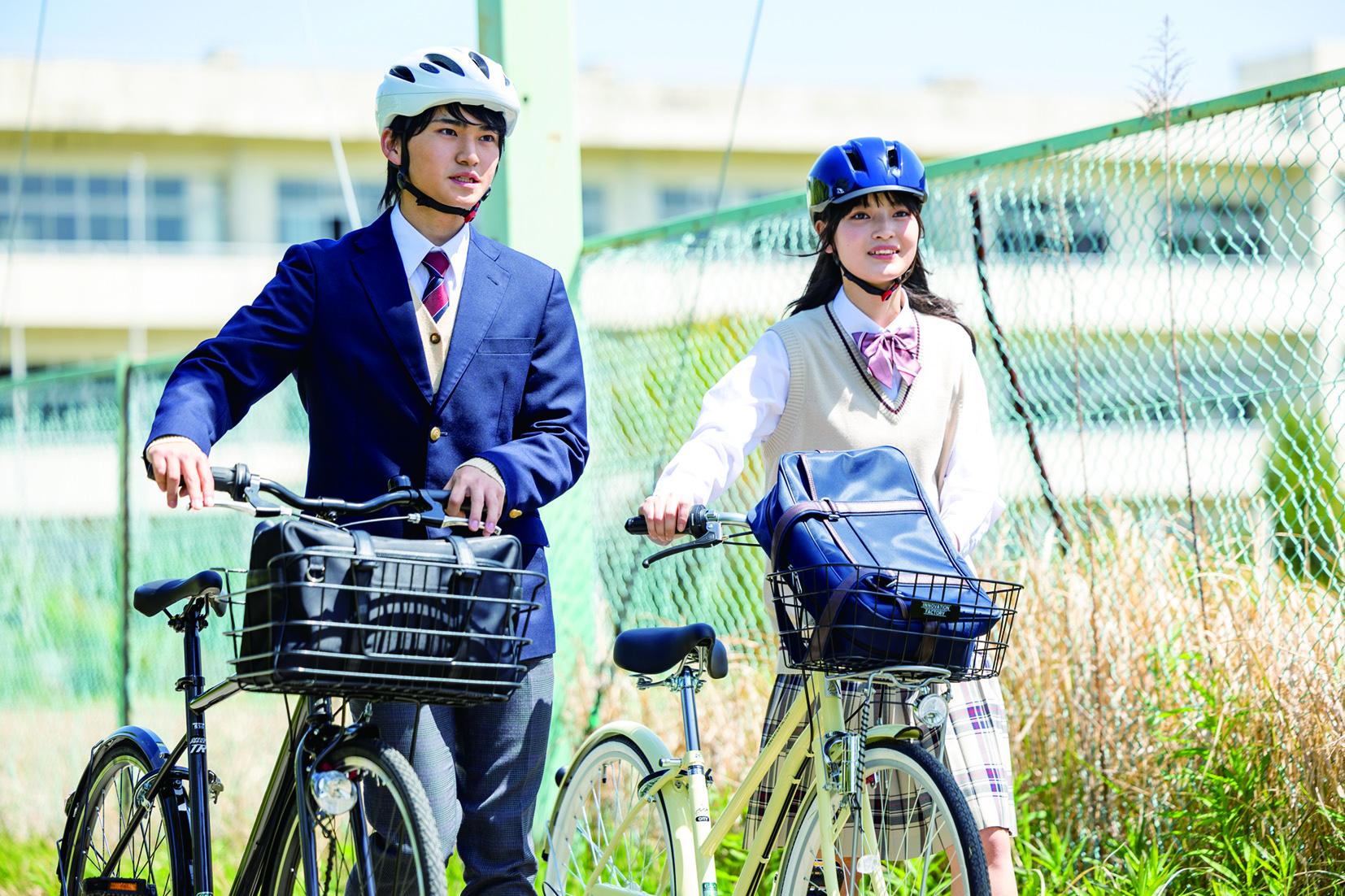 ヘルメットをかぶって自転車通学をしている学生