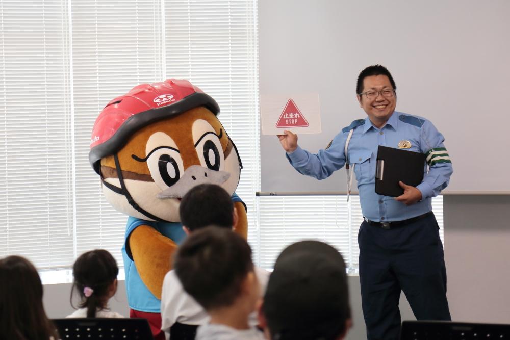 もずやんと止まれ標識を持った警察官